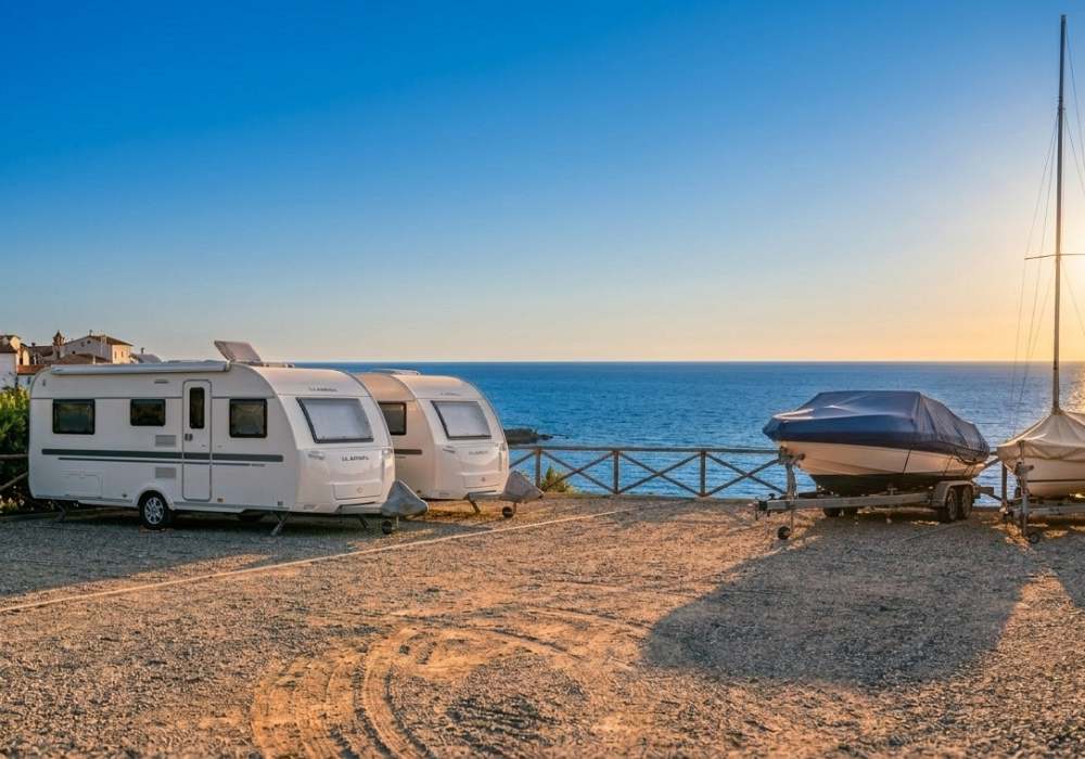 Roulotte e barche in rimessaggio con vista mare al tramonto — servizio professionale trasporto e rimessaggio roulotte e barche Camping Nautica Marcon